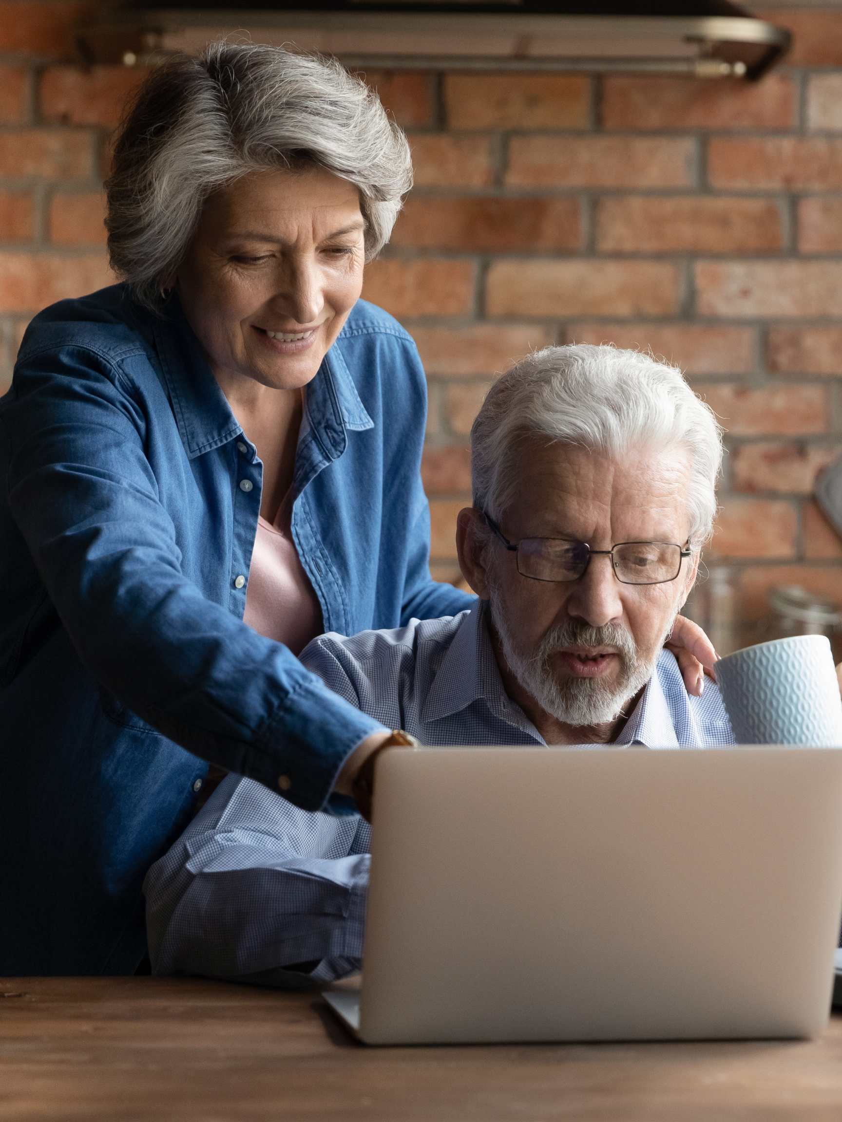 Happy middle aged family couple using computer.